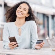 Online shopping, phone and woman doing digital credit card payment via internet at a restaurant. Happy, smile and person making a money transfer or cash send via online banking app or fintech website