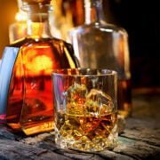 Glass and bottle of whiskey on a wooden table